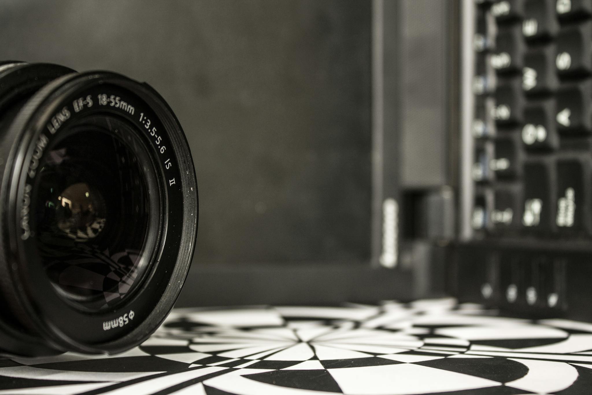 Detailed shot of a camera lens near a laptop keyboard, showcasing optical technology.