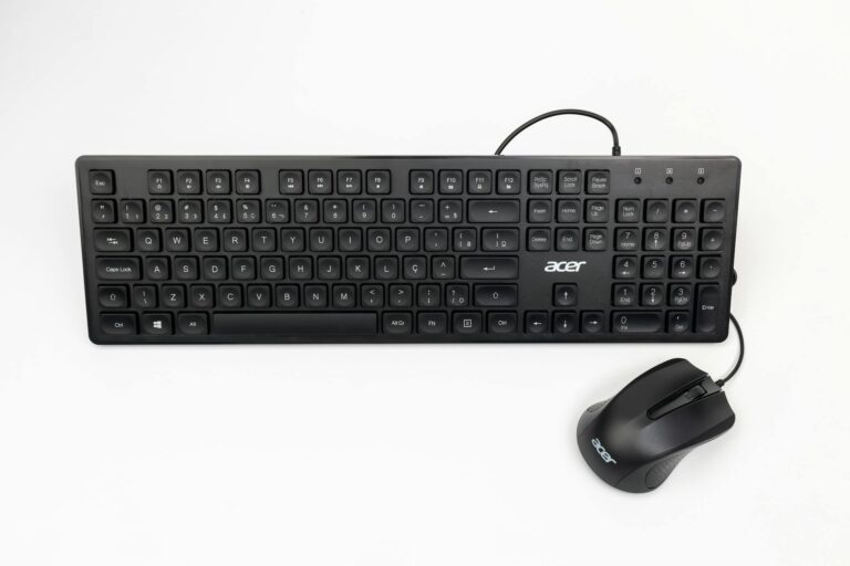 Clavier noir et souris filaire vus du dessus sur un bureau blanc