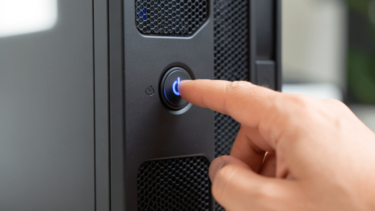 Main qui appuie sur le bouton d'alimentation d'un PC de bureau