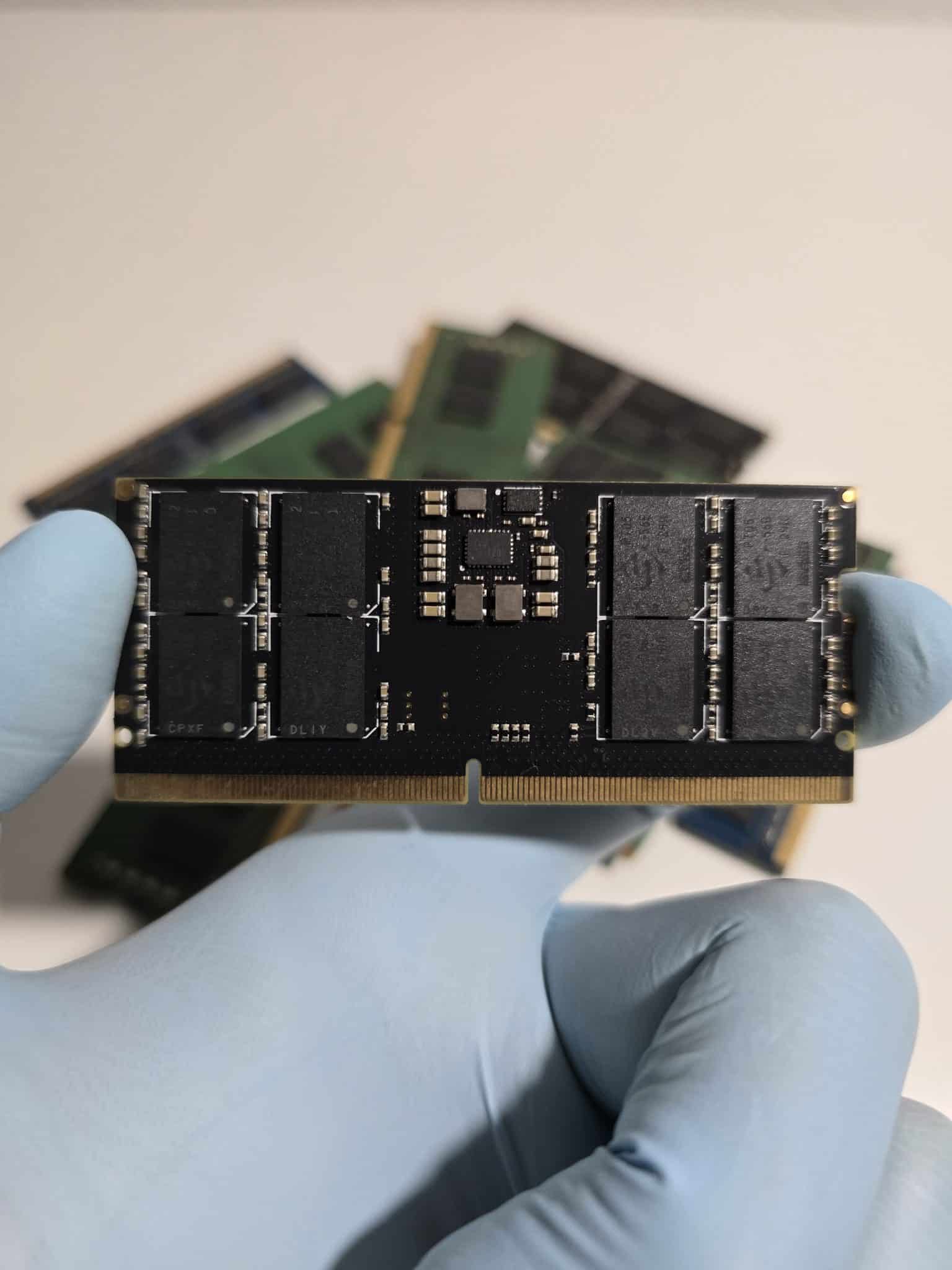 Main gantée tenant une barrette de mémoire SO-DIMM DDR5, format court utilisé dans les PC portables