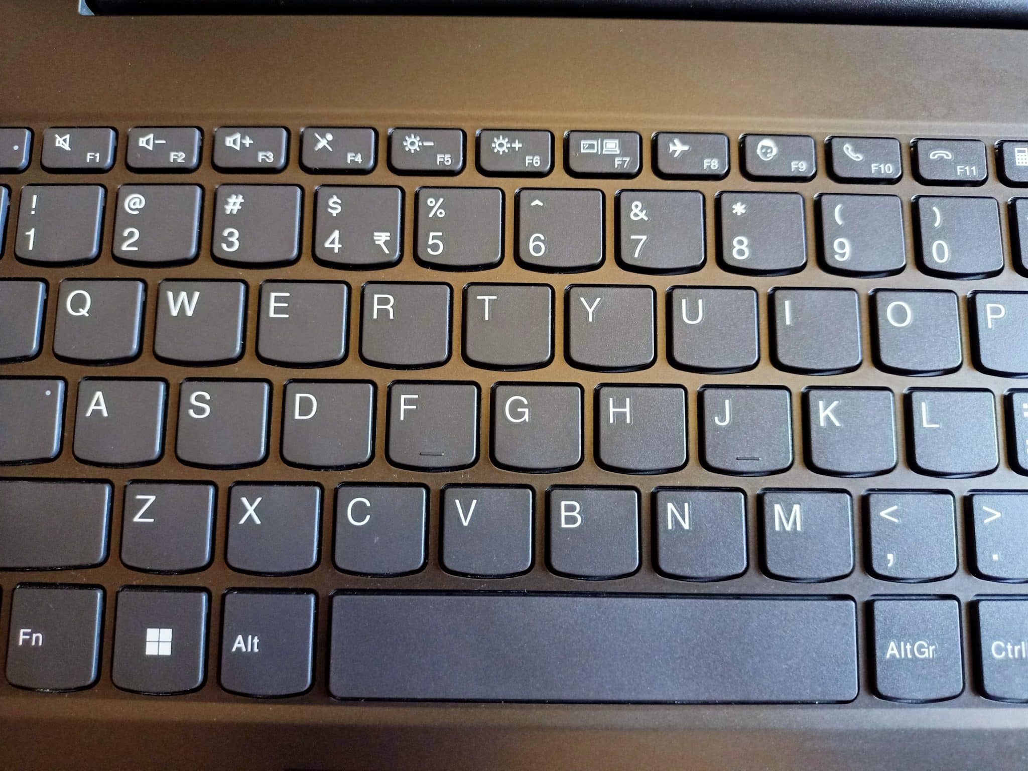Clavier de PC Windows vu de près, touche Windows et rangée de touches de fonction avec l'icône d'avion visibles