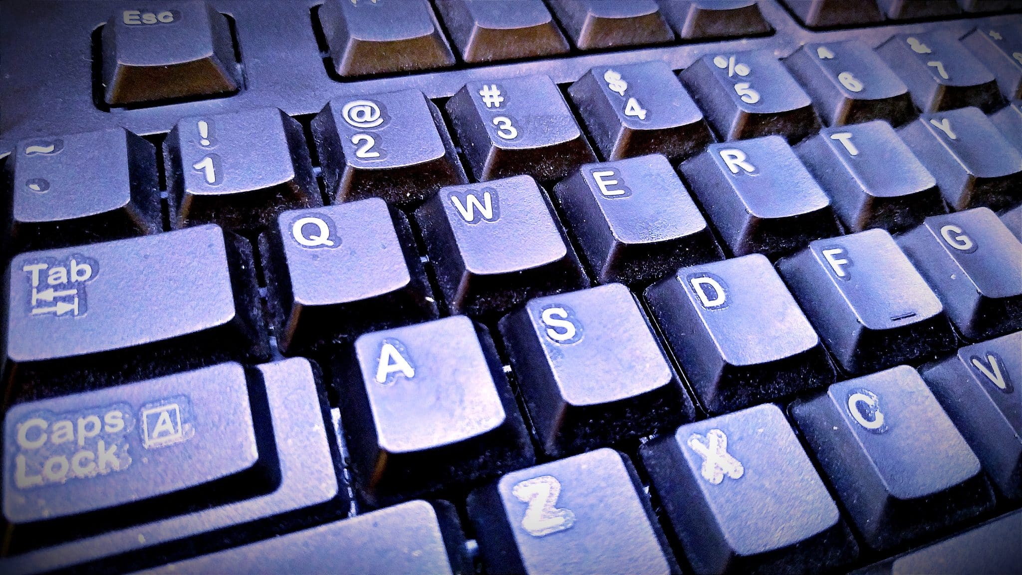 Clavier d'ordinateur très encrassé, poussière et résidus collés entre les touches autour de la touche Caps Lock