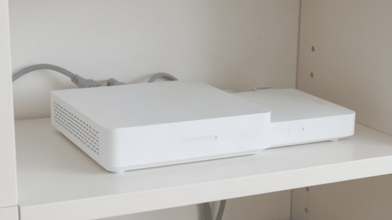 Box internet blanche et routeur avec voyants allumés et deux câbles réseau branchés