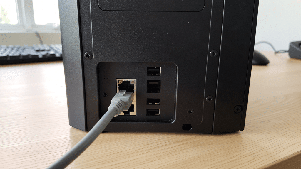 Câble réseau Ethernet branché sur le port à l'arrière d'une tour de PC de bureau