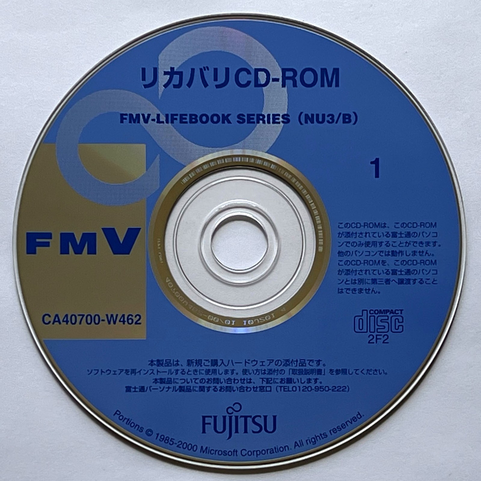 Disque CD-ROM posé sur une surface claire, exemple de disque à insérer dans un lecteur de PC