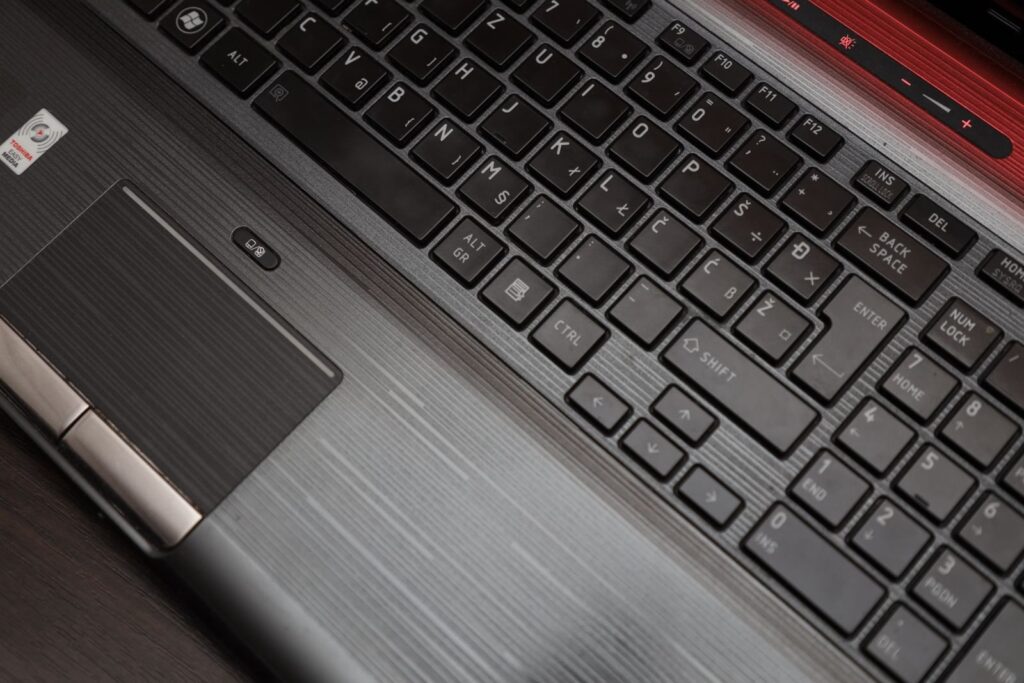 Pavé tactile d'un PC portable Windows avec ses deux boutons de clic et, au-dessus, le petit bouton qui active ou désactive le pavé