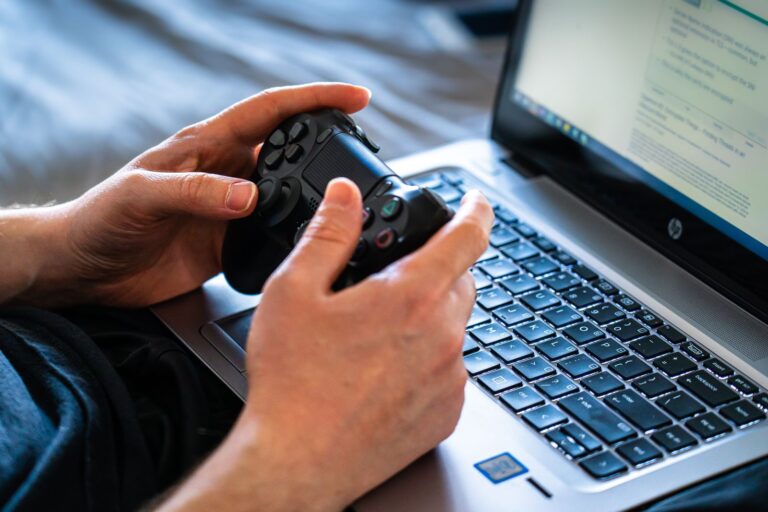 PC portable HP sous Windows, une manette de jeu dans les mains de l'utilisateur