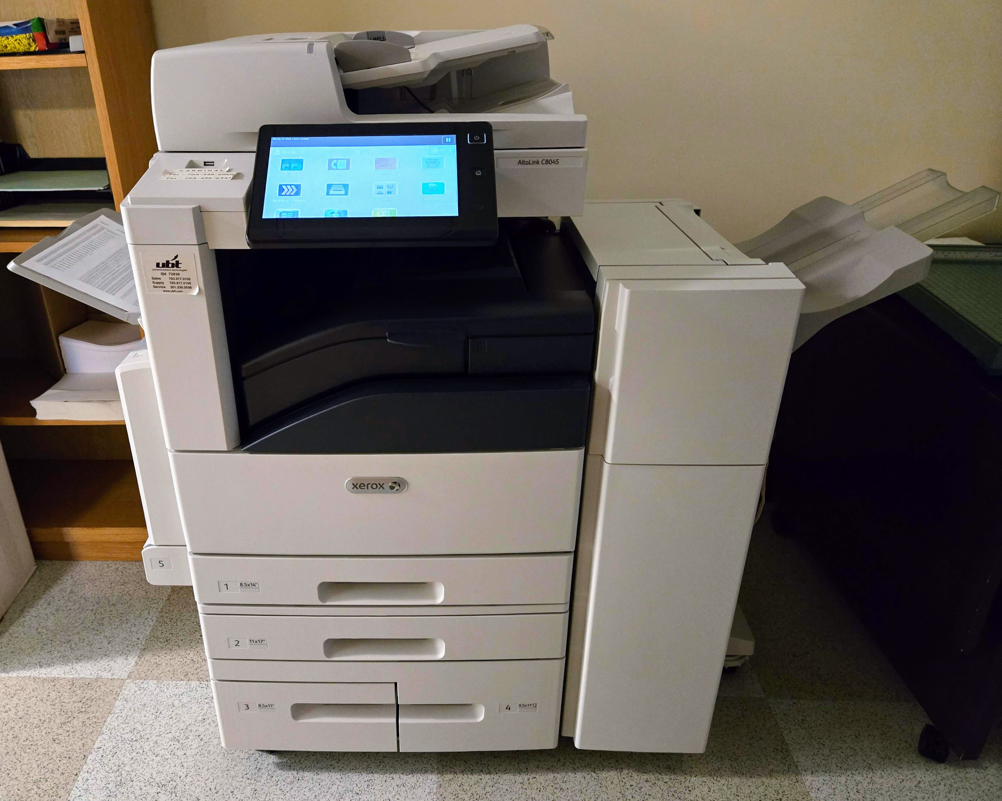 Photocopieur multifonction de bureau près d'une table, vue de trois quarts