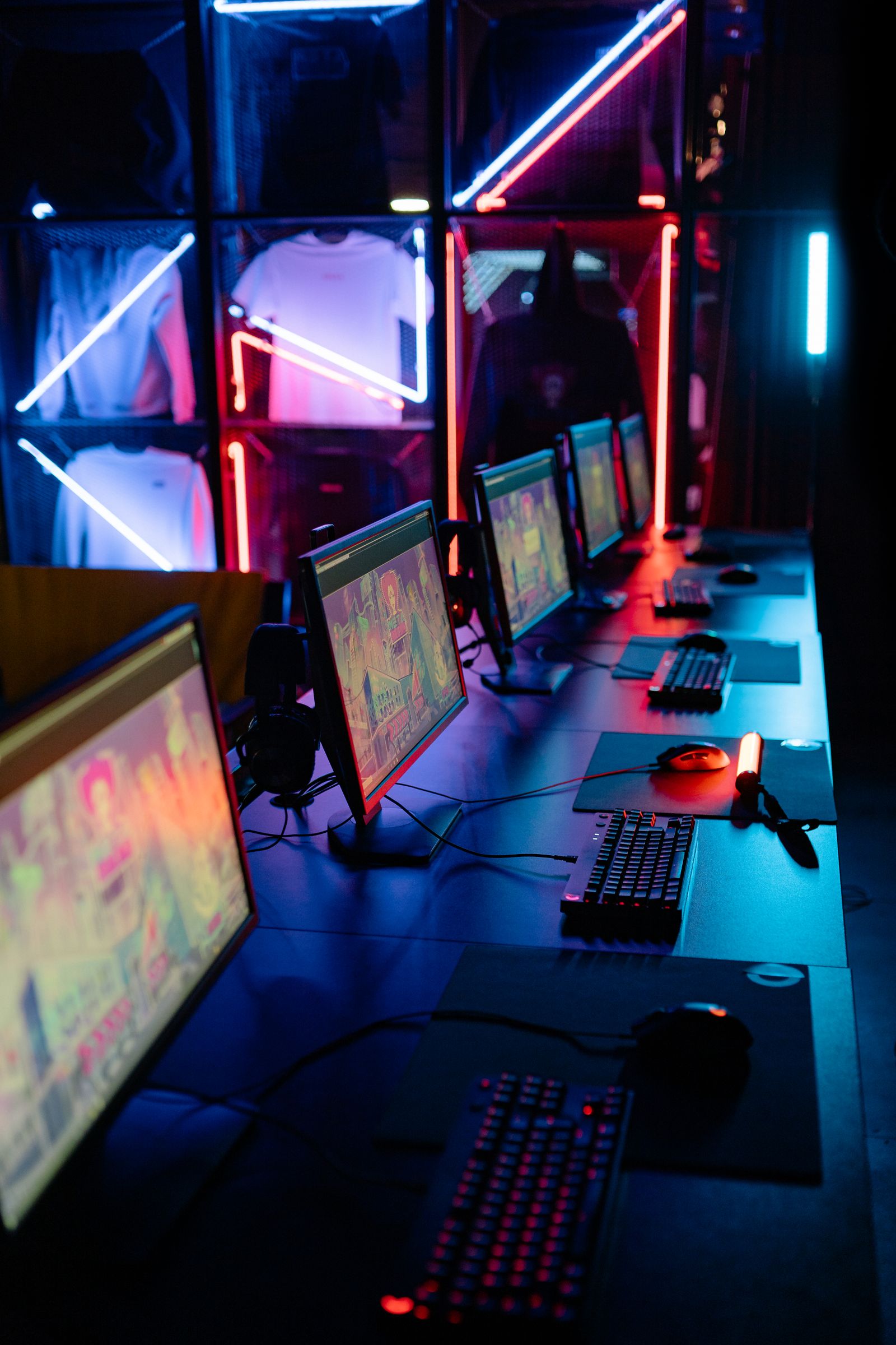 Rangée de postes PC avec écrans, claviers rétroéclairés et souris, reliés au même réseau local