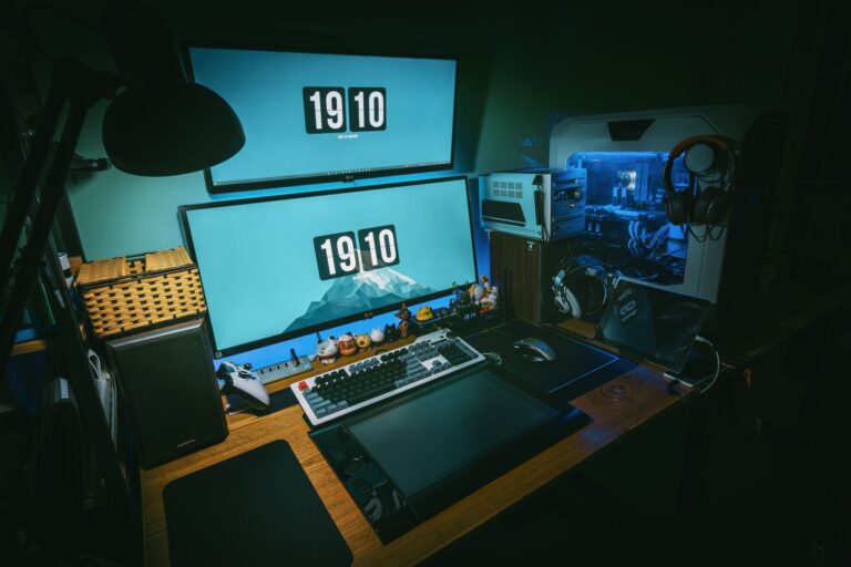 Bureau avec deux écrans empilés, clavier mécanique, souris et tour de PC éclairée